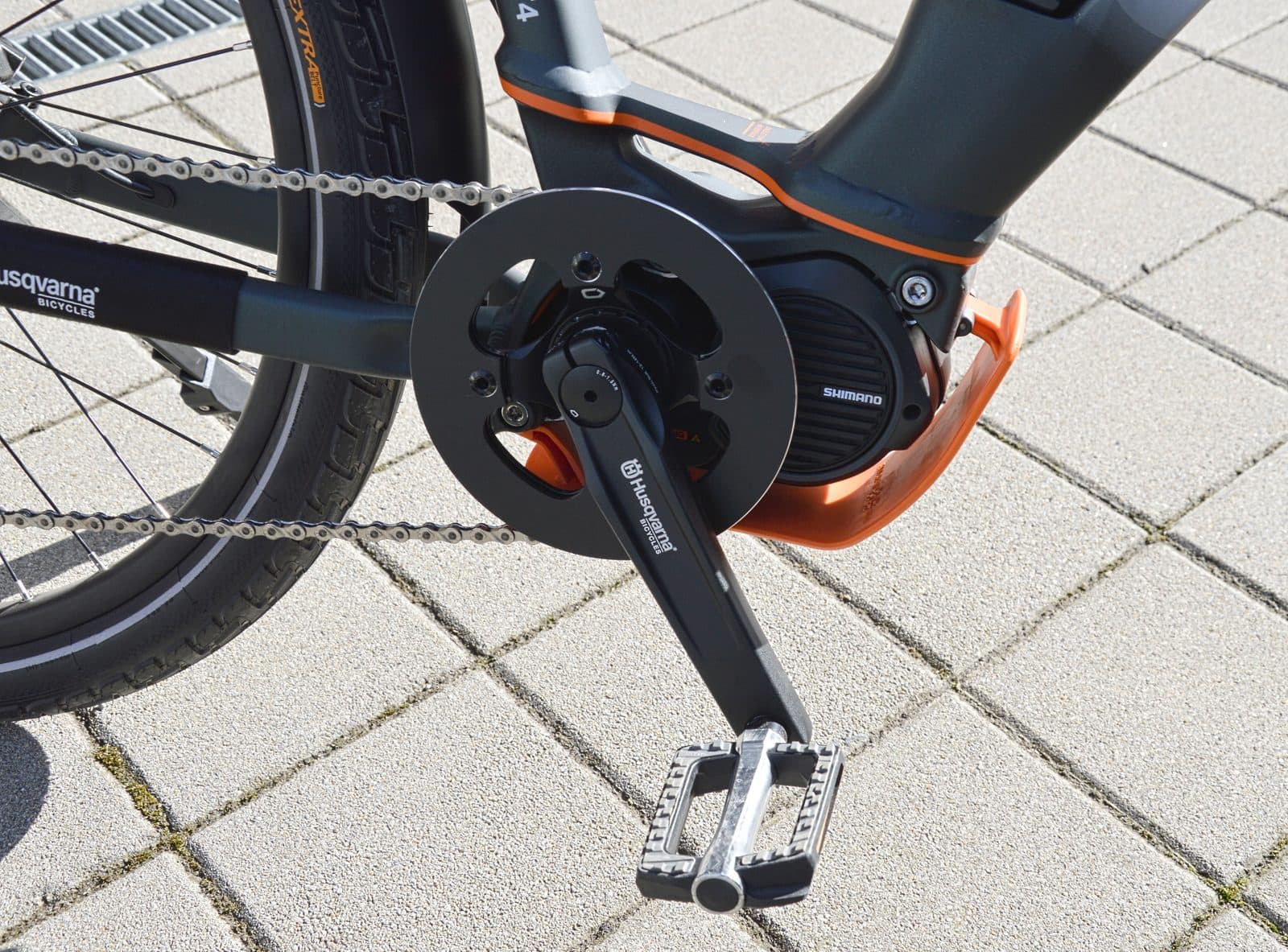 Shimano STePS DU-E6100-middenmotor op een Husqvarna-e-bike, close-up van crank, kettingblad, ketting en motorhuis met Shimano-logo