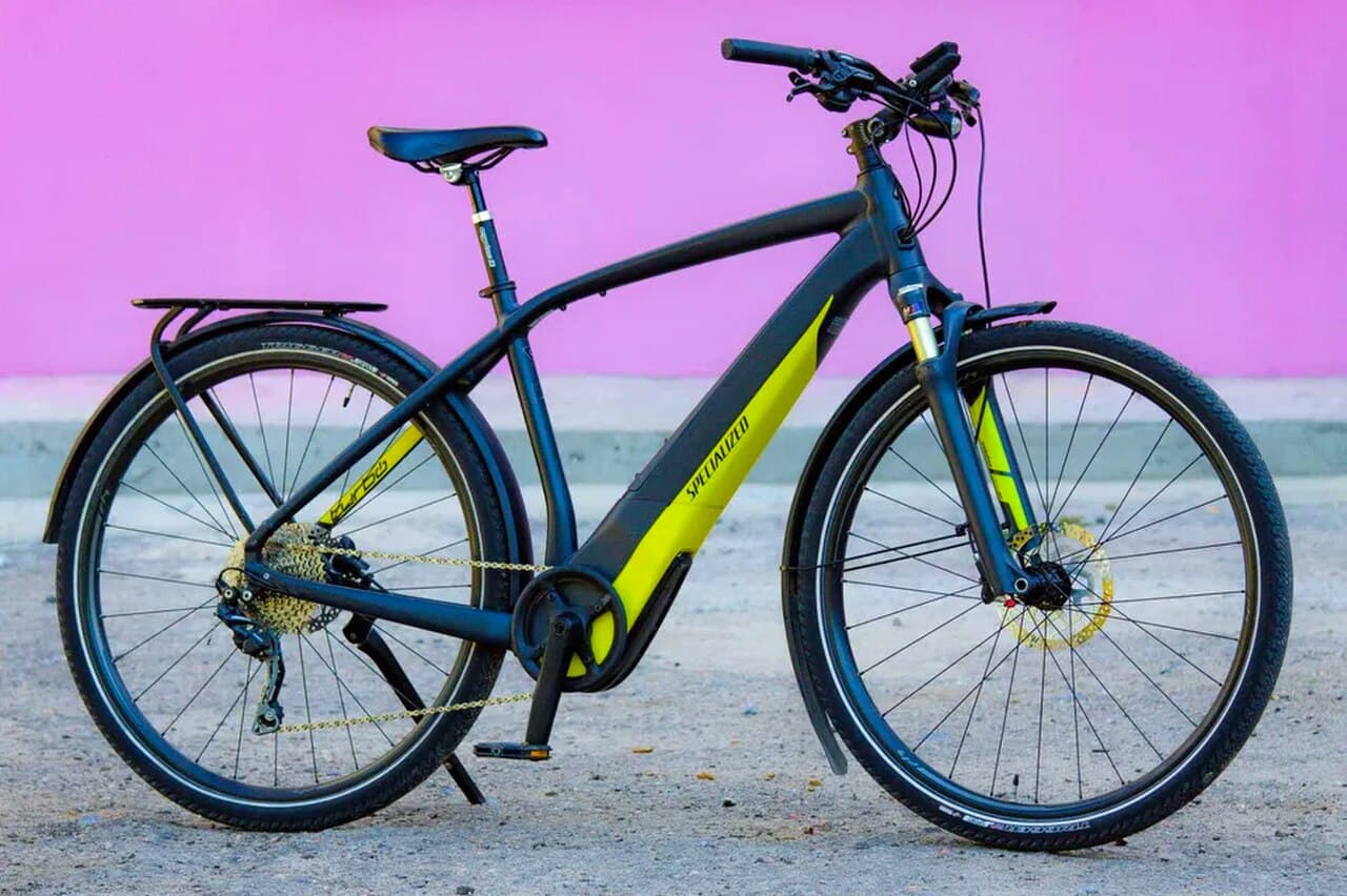 Specialized Turbo Vado 3.0, een stads-e-bike van hetzelfde merk, tegen een roze muur; archieffoto en niet de Turbo Como SL zelf