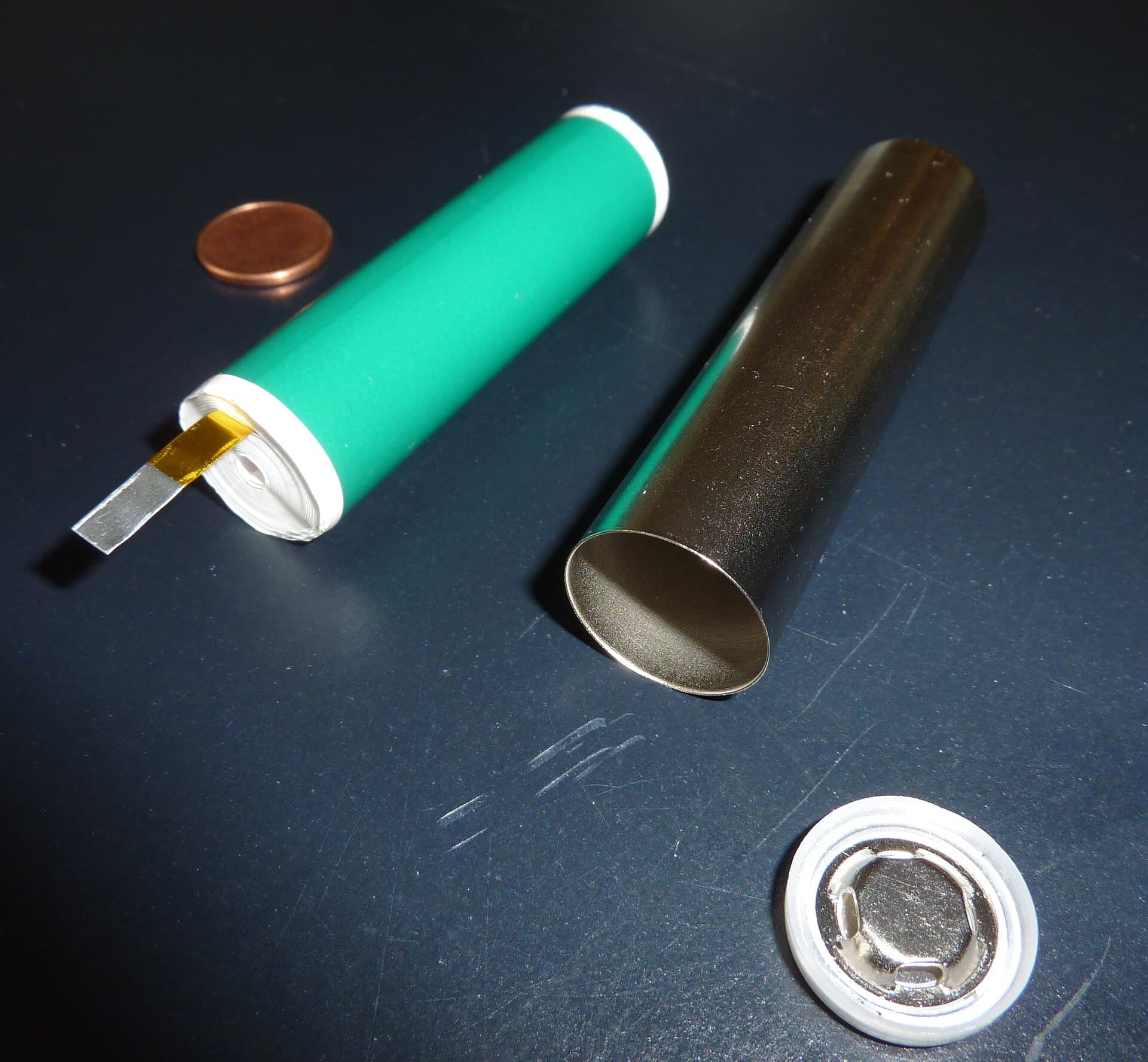 Geopende lithium-ion accucel naast een muntstuk