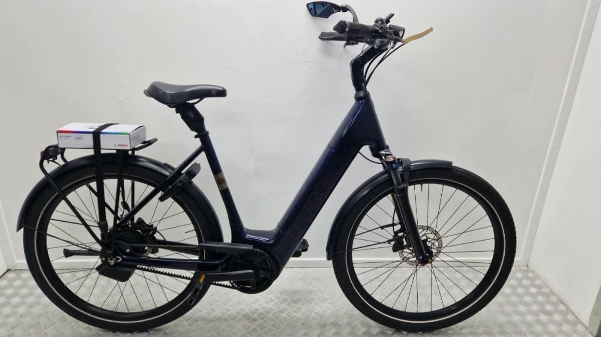 Donkerblauwe Trek District elektrische stadsfiets met lage instap, Bosch-middenmotor en riemaandrijving, zijaanzicht